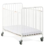 Berço dobrável para hotel Stowaway em aço branco com rodas e colchão. O design moderno destaca a estrutura robusta e o sistema de segurança com travões nos rodízios
