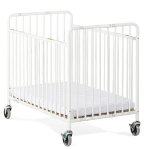Berço dobrável para hotel Stowaway em aço branco com rodas e colchão. O design moderno destaca a estrutura robusta e o sistema de segurança com travões nos rodízios