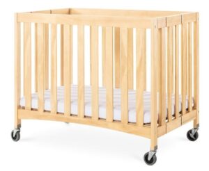 Berço de hotel dobrável em madeira clara modelo Travel Sleeper com rodas e colchão branco"
